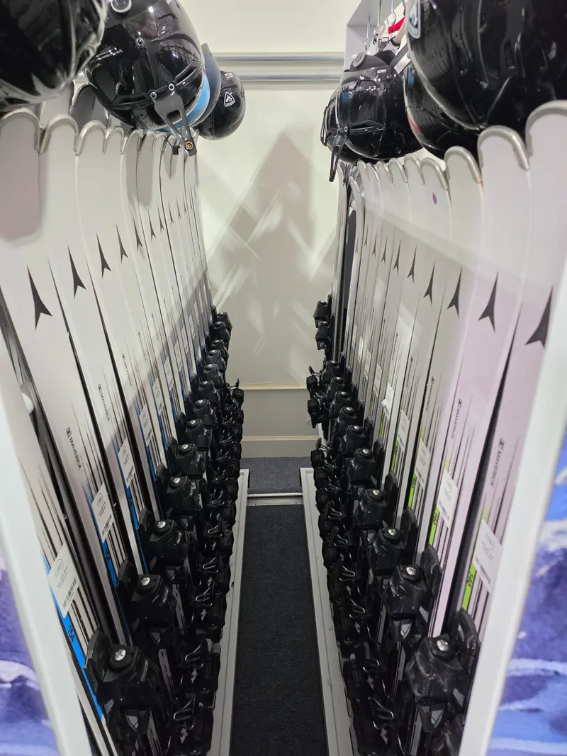 Atomic Maverick skis on racks with helmets hanging above