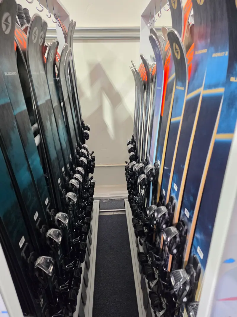 Blizzard skis with bindings standing on rolling racks